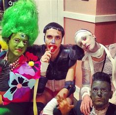 four people dressed up in costumes posing for a photo with their faces painted like clowns