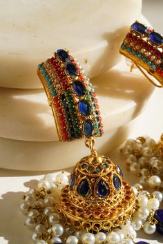 Elevate your style with our exquisite "Navdeep Jhumka Earrings." These heritage-inspired jhumka earrings are the perfect fusion of tradition and elegance. Crafted to perfection, they come in three primary color options, all in gold plating: ruby, blue, or gold, allowing you to choose the perfect match for your ensemble. Key Features: Color Options: Available in ruby, blue, or gold Dimensions: Approximately 3.5 inches Embellishments: Adorned with beautiful multi-color stones and embellishments Qu Gold Fusion Jhumkas With Peacock Design, Multicolor Chandbali Jhumkas With Intricate Design, Festive Fusion Jhumkas With Peacock Design, Multicolor Fusion Jhumkas For Diwali, Fusion Style Multicolor Jhumkas For Diwali, Multicolor Drop Earrings Jhumkas For Festive Season, Multicolor Festive Drop Jhumkas, Fusion Style Chandbali Jhumkas With Peacock Design, Traditional Blue Earrings With Intricate Design