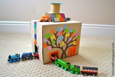 a toy train is coming out of a box with the letters happy birthday written on it