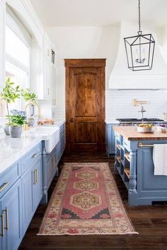 a kitchen with blue cabinets and an area rug