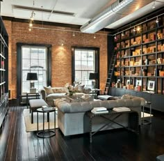 a living room filled with lots of furniture and bookshelves next to a window