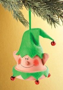 an ornament hanging from a christmas tree with a green hat on it's head