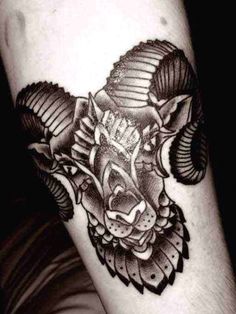 a black and white photo of a ram tattoo on the left arm, with an arrow in it's center