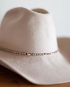 The perfect addition to any hat, our beaded hat bands feature a variety of semi-precious gemstones with leather ties for an adjustable closure to fit any hat. Dimensions: 21" beaded length before leather ties Material: Various Stones/Beads, Leather Cording Hardware: Gold Plated Jump Rings and Crimp Beads Closure: Leather Ties - brown for all stone options except pyrite, which uses black Stone Options: African TurquoiseTurquoiseLabradoritePyriteWhite HowlitePicasso JasperAqua Terra Jasper Handmad