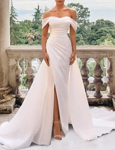 a woman in a white dress standing on a balcony