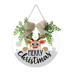 a christmas ornament hanging on a wall with a reindeer and holly wreath around it