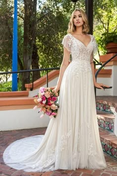 a woman in a wedding dress standing on some steps