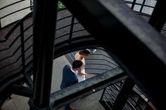 a man sitting on top of a stair case next to a woman walking down it