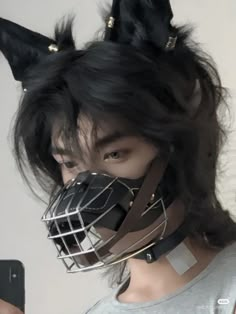 a person wearing a mask and holding a cell phone in front of their face with long black hair