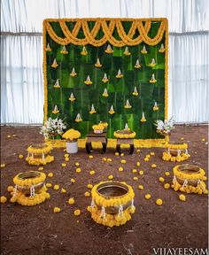 a decorated stage set up with yellow flowers on the ground and decorations in front of it