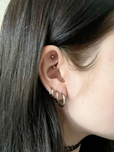 a close up of a person with ear piercings on their ears and behind them is a black chain