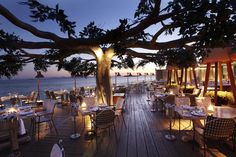 an outdoor dining area overlooking the ocean at dusk