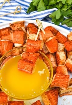 a plate with tofu skewers and an orange dipping sauce in a small bowl