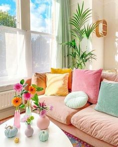 a living room filled with lots of furniture and flowers in vases on the coffee table