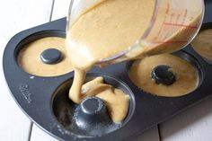 a batter being poured into a muffin tin