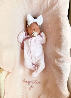 a baby is sleeping on a pink blanket