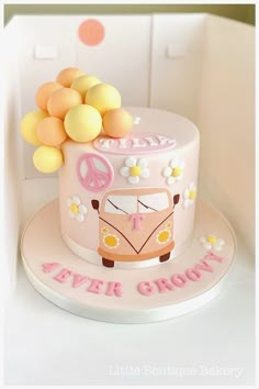 a pink cake decorated with flowers and a vw bus