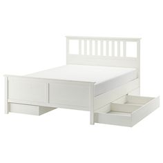 a white bed with drawers underneath it and an open drawer on the bottom half of the bed