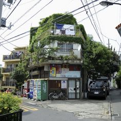 an apartment building with plants growing on the roof