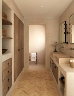 an empty bathroom with two sinks, mirrors and wooden flooring is pictured in this image