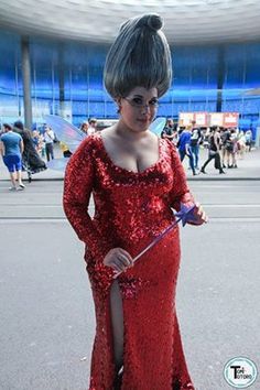 a woman in a red sequin dress holding an umbrella