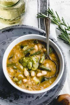 a bowl of soup with beans, broccoli and other vegetables on the side