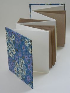 four blank cards are lined up on a white surface with blue and brown floral designs