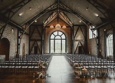 an empty church with rows of chairs and chandeliers on either side of the aisle