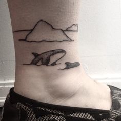 a small tattoo on the ankle of a woman's foot, depicting two dolphins