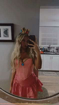 a woman taking a selfie in front of a mirror wearing a pink corset