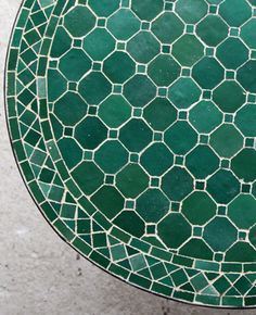 a green table with white and black designs on it's surface is seen from above