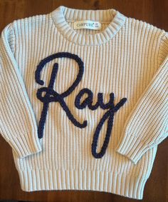 This personalized handmade embroidered oversized sweater is perfect for baby announcements, special occasions, or just because. Personalization is custom for each order, including font, sweater color and yarn color selections.  Infant through children sizes available for custom order. Name Sweater, Sweater Ideas, Baby Announcements, Embroidered Sweater, Baby Sweaters, Oversized Sweater, Gender Neutral Baby, Yarn Colors, Baby Announcement