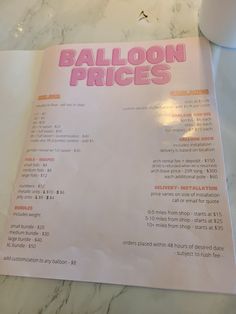 a menu for balloon prices on a marble table