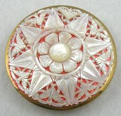 a white and red brooch sitting on top of a table