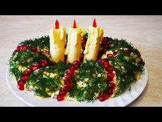 a cake decorated with pine cones and cranberries on a white plate topped with greenery