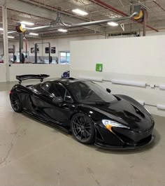 a black sports car parked in a garage with no one around it's doors