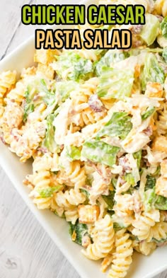 chicken caesar pasta salad in a white bowl on a wooden table with text overlay