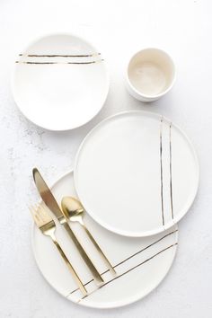 white plates with gold forks and knives on them