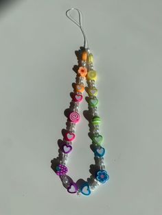 two bracelets made out of beads with hearts and flowers on the end, hanging from a hook