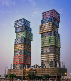 two very tall buildings sitting next to each other in the middle of a city at night