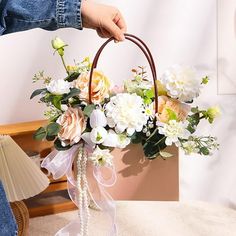 a person holding a basket with flowers in it