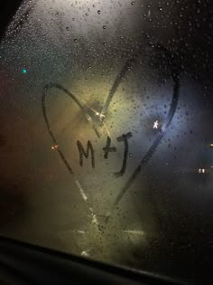 a heart drawn on the window with rain drops