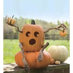 two pumpkins sitting on top of each other in front of a fence with antlers