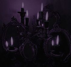 a group of mirrors sitting next to each other in front of a wall with candles