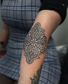 a woman's arm with a tattoo on it and an ornate design in the middle