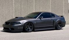 a gray car parked in front of a wall