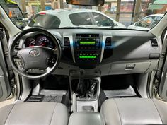 the interior of a car with grey leather seats and dash board on display in a showroom