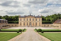 an image of a large building with hedges in front