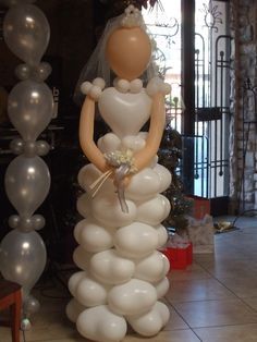 a wedding cake made out of balloons in the shape of a bride and groom standing next to each other