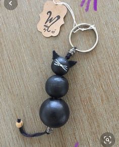 a keychain with two black balls on it and a tag attached to it